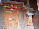 Tibet Guge 03 Tholing 06 White Temple Entrance Door The entry to Tholing's White Temple is marked by two interesting deodar (cedar) columns originating in India, probably 500 years old. Along the left and right walls of Tholing�s White Temple are murals depicting a series of male and female bodhisattvas. Over three metres high, some of them are represented within a formal aureole, others within a celestial palace, and yet others in a natural landscape setting of mountains and forests.